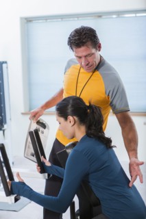 Woman working with personal trainer in gym