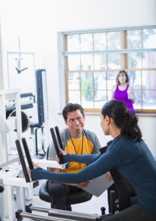 Woman working with personal trainer in gym