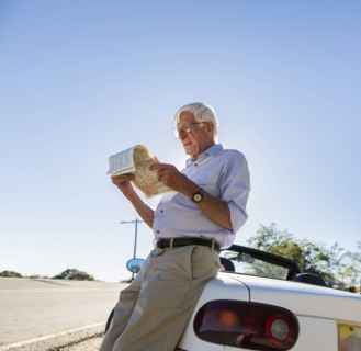 Senior Caucasian man reading map by road