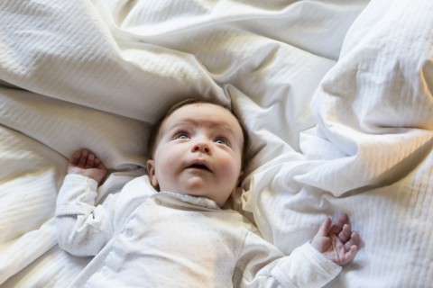 Caucasian baby boy laying in bed