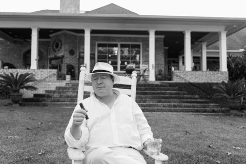 Caucasian man relaxing with cigar in yard