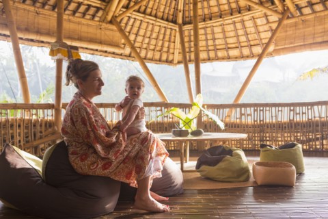 Caucasian mother bouncing baby on knee