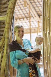 Caucasian mother holding baby in bamboo doorway