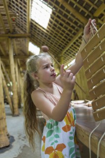 Caucasian girl playing with xylophone in workshop