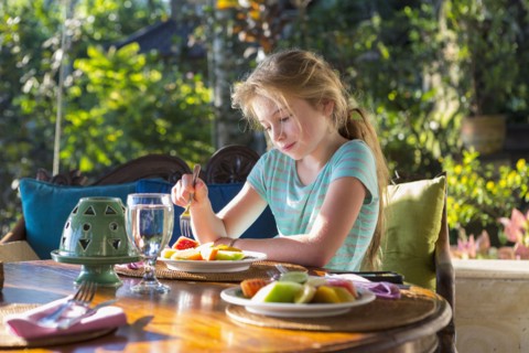 Caucasian girl eating breakfast at table