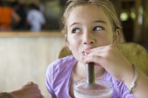 Caucasian girl drinking smoothie at breakfast