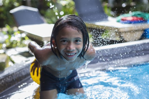 Balinese boy playing in swimming pool