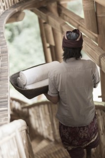Balinese man carrying rolled towels in hotel
