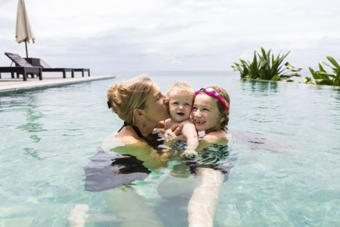 Caucasian family relaxing in infinity pool