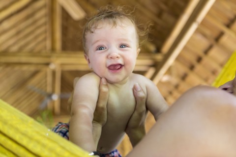 Caucasian mother holding baby in hammock