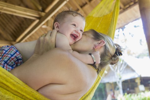 Caucasian mother holding baby in hammock
