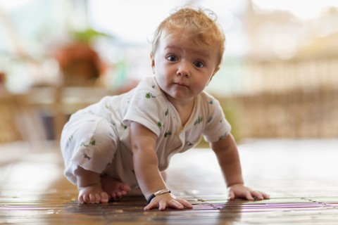 Caucasian baby crawling on floor