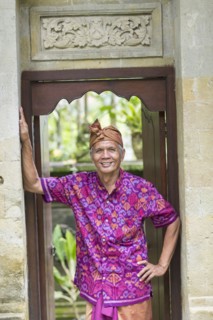 Balinese worker smiling in wood archway