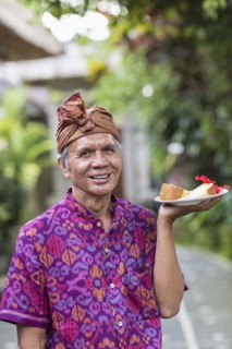 Balinese server carrying plate of food