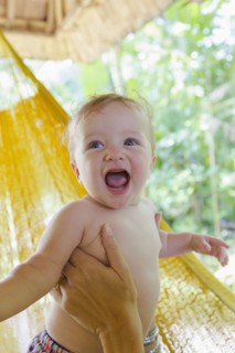 Caucasian mother holding baby in hammock