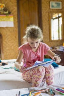 Caucasian girl coloring in bedroom