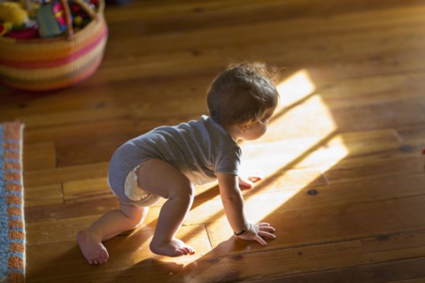 Caucasian baby crawling on floor