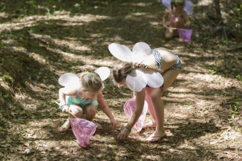 Caucasian girls playing dress up in forest