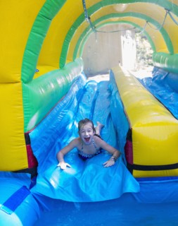 Caucasian girl laughing on water slide