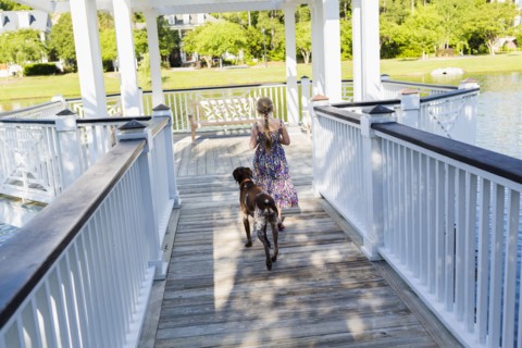 Caucasian girl walking with dog in gazebo