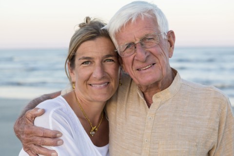 Caucasian father and daughter smiling on beach