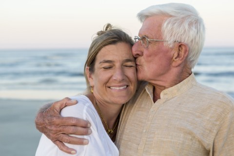 Caucasian father kissing daughter on beach