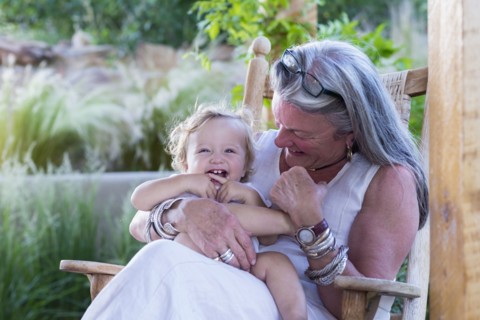 Caucasian older woman holding grandson in rocking chair