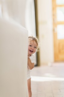 Caucasian baby boy playing hide and seek