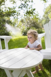 Caucasian baby boy sitting at table in backyard