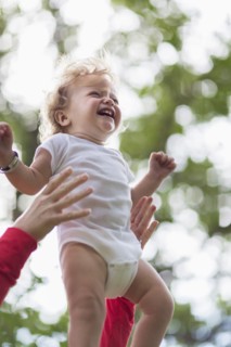 Caucasian mother playing with baby boy outdoors