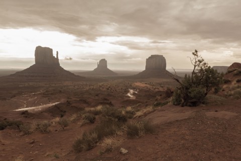 Rock formations in desert under cloudy sky