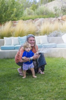 Caucasian grandmother hugging baby grandson in backyard