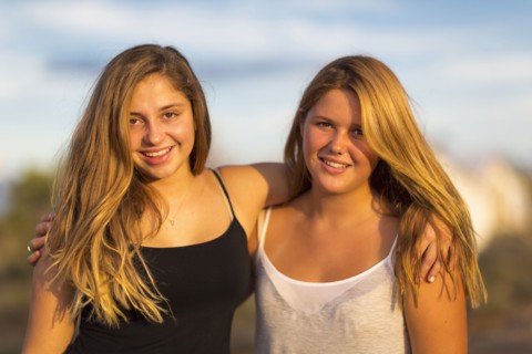 Teenage girls hugging outdoors