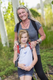 Caucasian grandmother and granddaughter smiling in forest