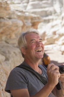 Older Caucasian man photographing rock formations