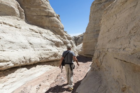 Older Caucasian man exploring rock formations