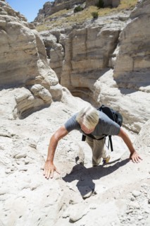 Older Caucasian man climbing rock formations