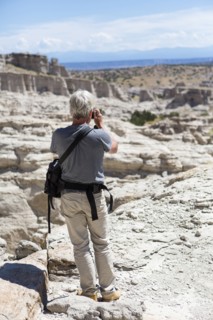 Older Caucasian man photographing rock formations