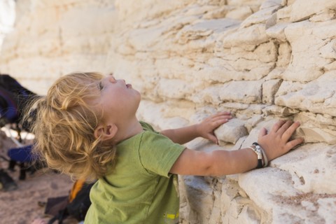 Caucasian baby boy exploring rock formations