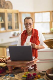 Older mixed race woman using laptop in home office