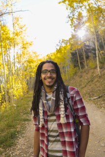 Mixed race man hiking in forest