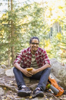 Mixed race hiker smiling in forest