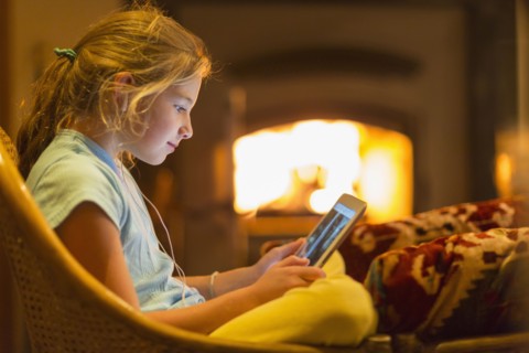 Caucasian girl using digital tablet in living room