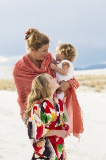 Caucasian mother and children laughing on sand dune