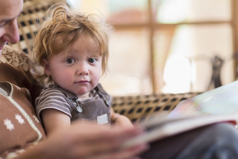 Caucasian mother reading to son in chair