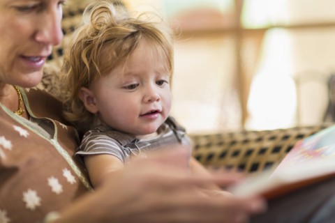 Caucasian mother reading to son in chair