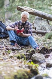 Caucasian hiker writing in forest