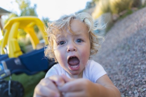 Caucasian boy shouting in backyard