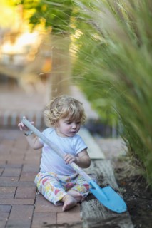 Caucasian boy playing with spade in garden