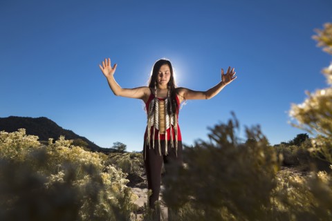 Mixed race woman meditating in remote desert landscape